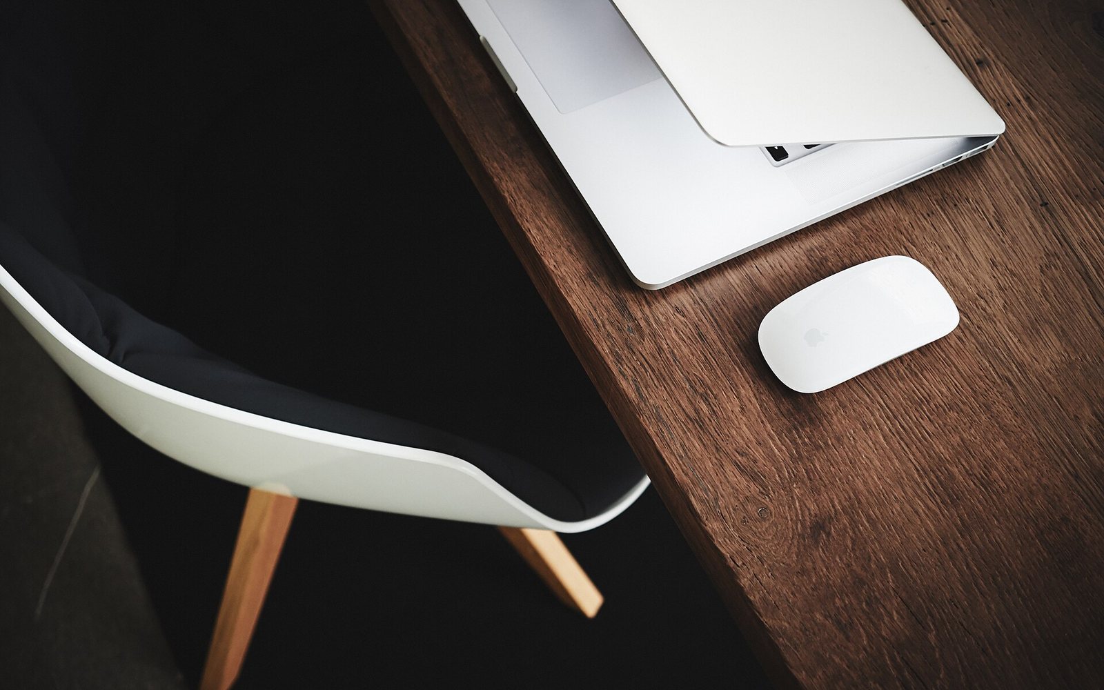 A tidy desk with a laptop and a chair